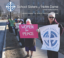 The image features the cover of the second volumn of the  donor newsletter, released in June 2021. Sister are holding signs at Notre Dame of Elm Grove, Elm Grove, Wisconsin to stand for Peace and Unity. 