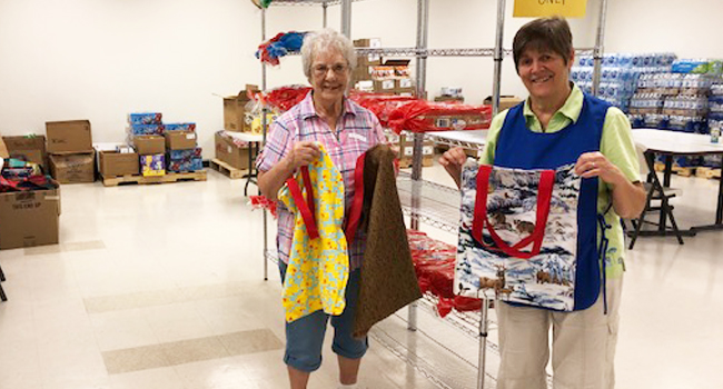 Sisters and lay people have been asked to volunteer in El Paso, Texas, to help immigrants transition into the United States. Sister Antoinette Nauman and volunteer Karina are showing off the bags sewn by St. Louis sisters and donated to the center. 