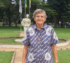 Sister Ann Coleman is posing for a picture in front of a statue at Notre Dame High School in Sunyani, Ghana. 