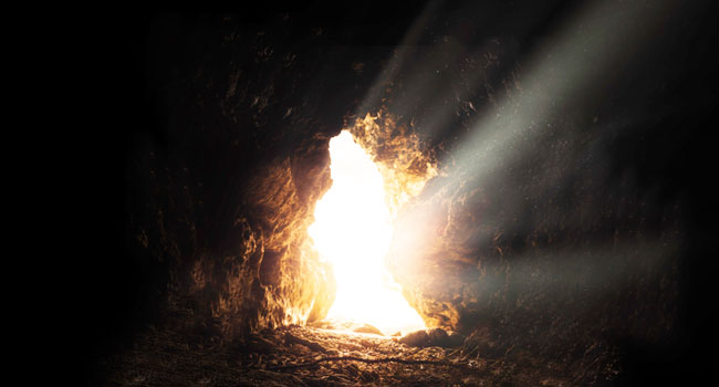 An image inside of a cave while bright light shines through an opening. This image symbolizes Jesus walking out of his tomb. 