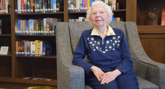Sister Jackie Buckley sitting in the library at Trinity Woods on the Mount Mary University campus in Milwaukee. 