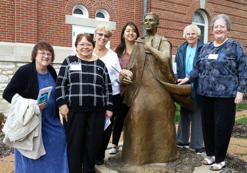 Sisters and Associates stand in front of the Blessed Theresa statues, located at Sancta Maria in Ripa in St. Louis. 