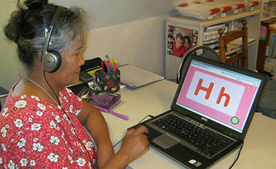 A student at MORE learning English letters on a laptop.