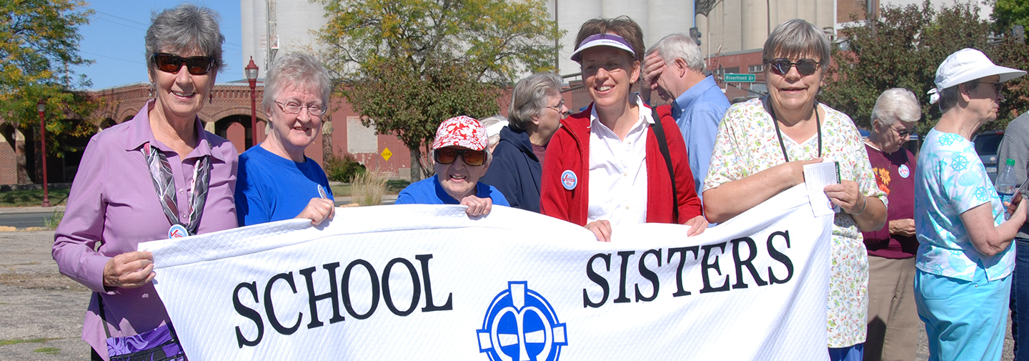 Sister Joyce Kolbet is featured in this photo with a group of other sisters holding up a School Sisters of Notre Dame banner. Sister Joyce wrote a reflection on Jubilee for her 50-year celebration. 