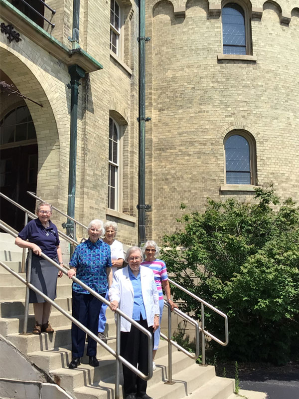 Sisters standing on steps at Notre Dame of Elm Grove, Elm Grove, Wisconsin. First row starting on the lower step: Mariel Kreuziger, Anton Marie Voissem, Paul Mary Draxler. The row behind starting on the lower step:  Marie Regine Redig, Margaret Mary Dohms