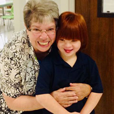 Sister Dawn Ach's posing with a student at Notre Dame of Dallas school. 