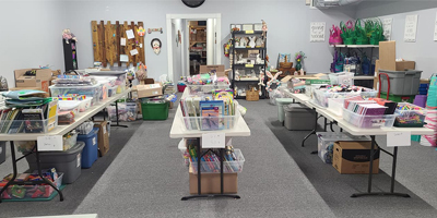 Alleluia Baskets has store where volunteers come in and pick and choose items to build baskets. This imagge is of the store room and the tables full of donated items ready to go in baskets. 