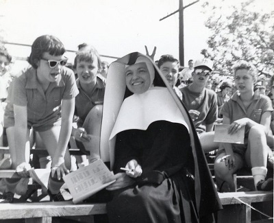 Historical photo of Sister Margaret (Claverine) Bloss sitting on bleachers with students