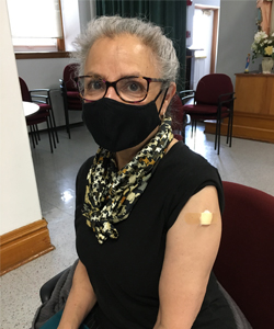 Sisters at Our Lady of Good Counsel, Mankato, Minnesota, recieve the COVID-19 vaccine. They hold up a picture that says, "fighting COVID one shot at a time.